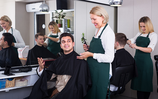 Portrait of a hairdresser with arms crossed in hairdressing salon