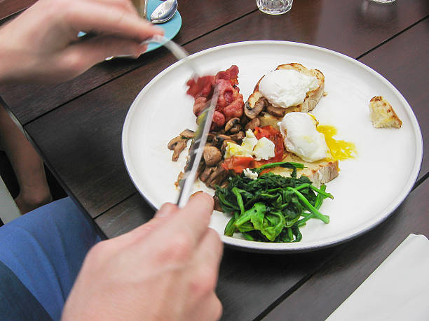 istock Young men eating vegetable, bacon, and poached eggs 498427916