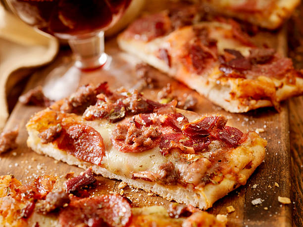 Flatbread Pizza All Meat Flatbread Pizza with Pepperoni, Italian Sausage and Bacon with a Glass of Red Wine -Photographed on Hasselblad H3D2-39mb Camera flatbread stock pictures, royalty-free photos & images