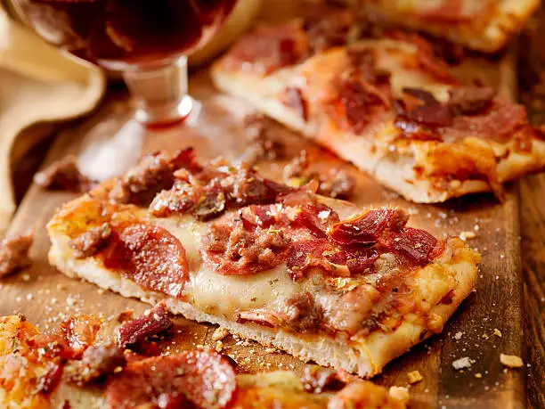 All Meat Flatbread Pizza with Pepperoni, Italian Sausage and Bacon with a Glass of Red Wine -Photographed on Hasselblad H3D2-39mb Camera