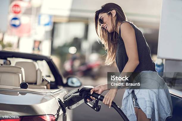 Beautiful Woman Refueling The Gas Tank At Fuel Pump Stock Photo - Download Image Now