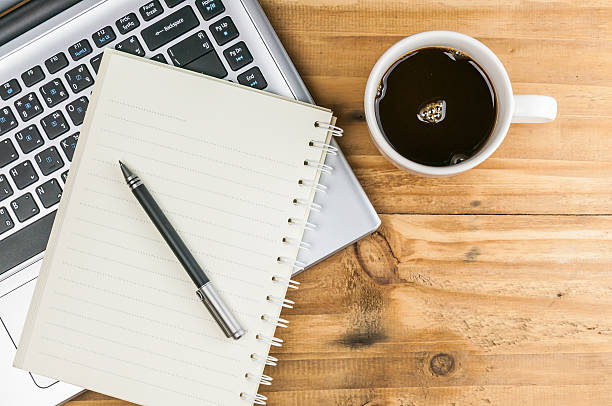 istock Laptop with coffee cup, notebook and pen on wooden background 498431562
