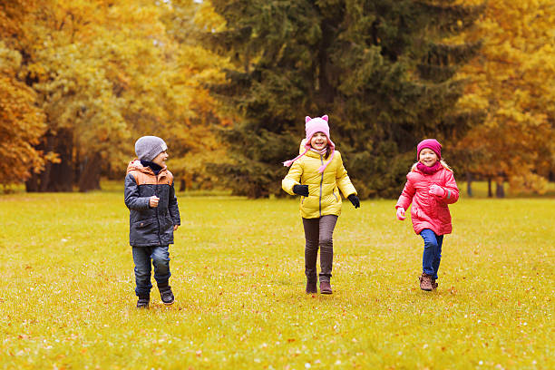pequeno grupo de feliz correr ao ar livre infantil - smiling little girls little boys autumn imagens e fotografias de stock
