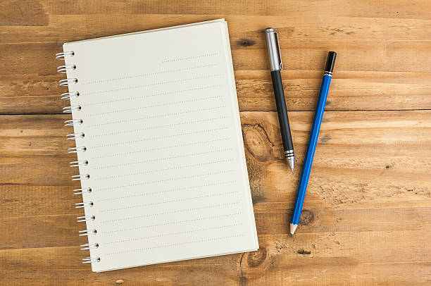 istock blank notebook with pen and pencil on wooden table 498431944
