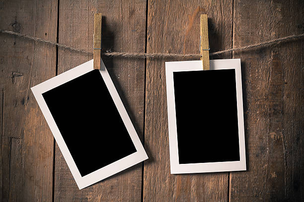 istock Blank Old Photo Frame Hanging on a Rope By Clothespin 498435230