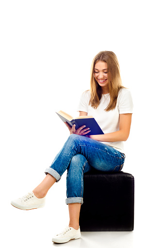 young girl reading book isolated on a white background