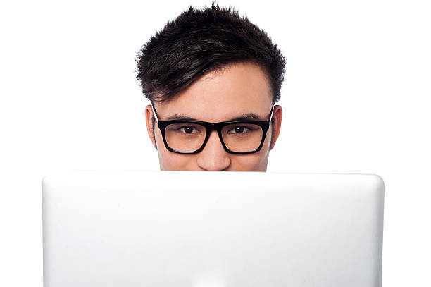 istock Boy trying to hide his face behind laptop 498444265