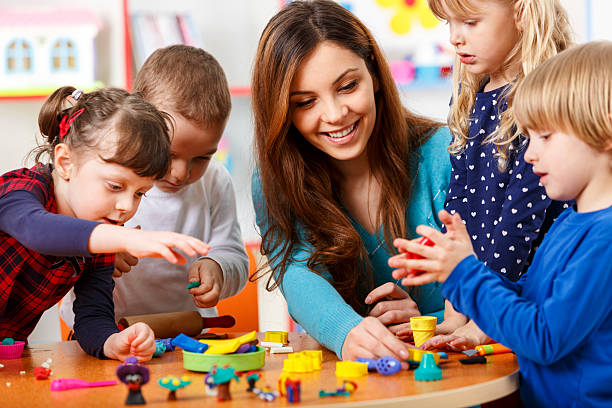 nursery maestro de jugar con los niños - estudiantes con el profesor de arte pintura fotografías e imágenes de stock