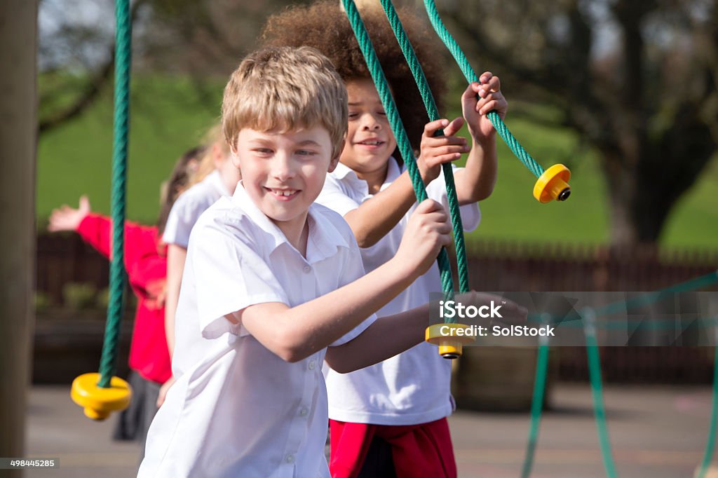 Active Kids School children at break time playing on climbing frame 6-7 Years Stock Photo