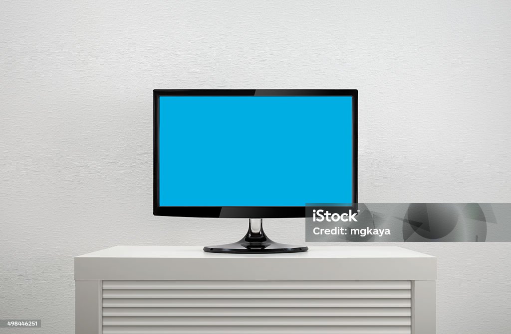 LCD TV on Cabinet Front view of high-definition flat screen LCD television (or computer monitor) with blank blue screen on white cabinet. Cabinet Stock Photo