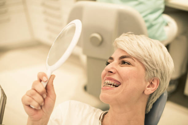 istock Happy young woman with retainer in dentist 498447623