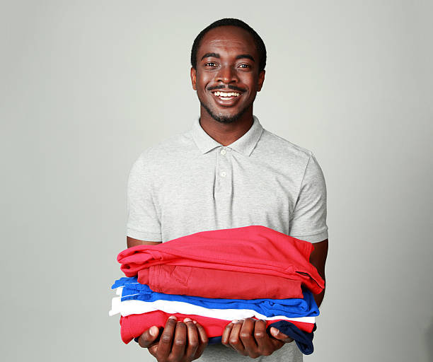 istock smiling african man holding his clothes 498447781