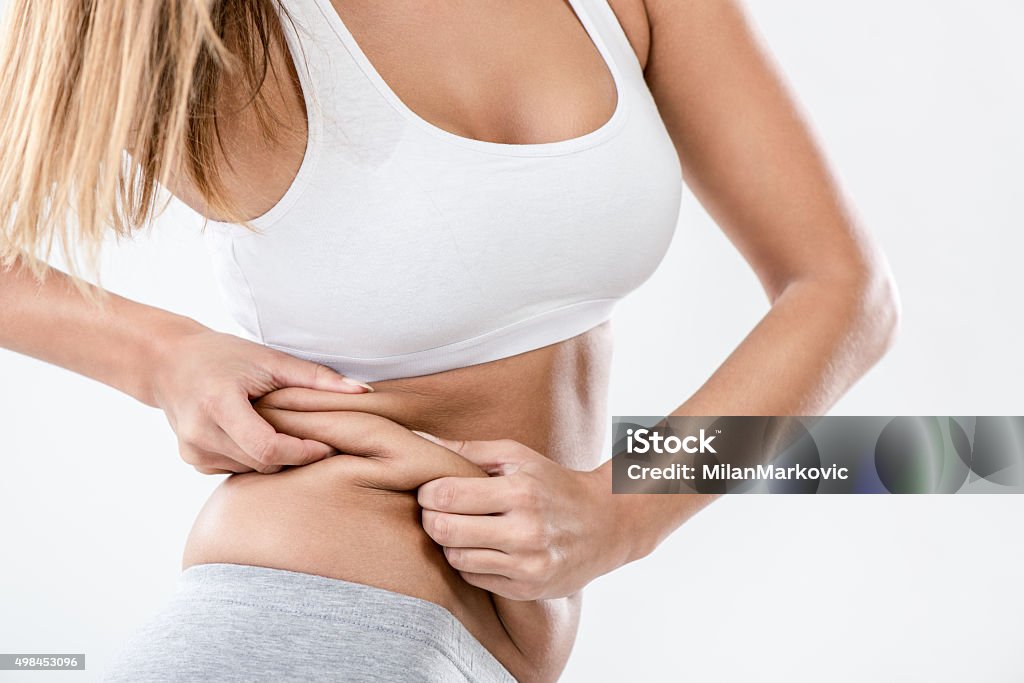 Pinching Fat Woman pinching waist and checking her body fat. Close-up. Overweight Stock Photo