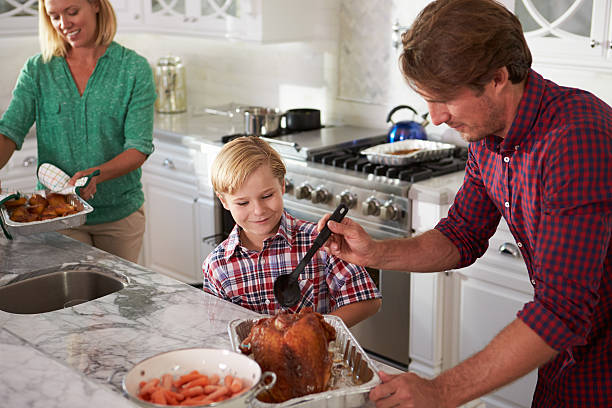 istock Father And Son Cooking Roast Turkey In Kitchen Together 498453550