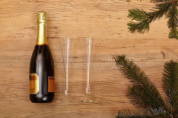 Champagner, glasses and fir twigs on wood