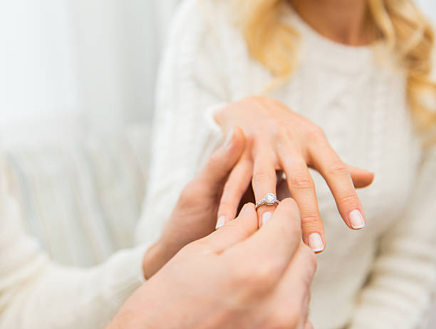 close up of man giving diamond ring to woman love, couple, relationship and holidays concept - close up of man giving diamond ring to woman diamond ring stock pictures, royalty-free photos & images