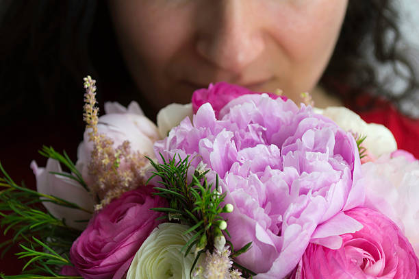istock woman smelling peonies 498460179
