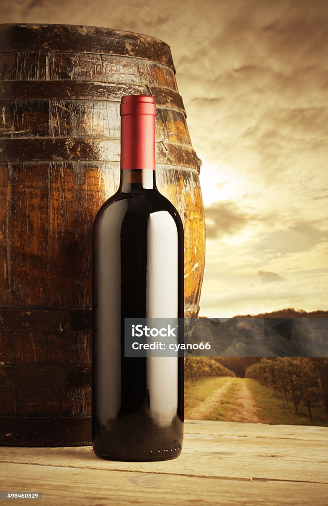 red wine bottle red wine bottle and wodden barrel, vineyard on background Wine Bottle Stock Photo
