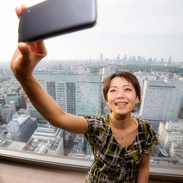 istock Tourist Taking Selfie with Tokyo on Smart Phone 498462448