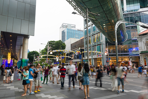Scene of busy Orchard Road, people are crossing a pedestrian crossing. Orchard Road decorates and lights up the street for Christmas festive season.
