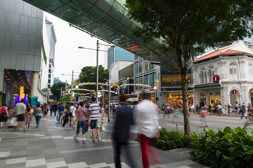 Scene of busy Orchard Road, people are crossing a pedestrian crossing. Orchard Road decorates and lights up the street for Christmas festive season.