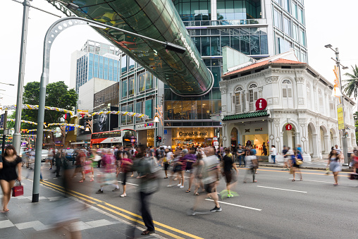 Scene of busy Orchard Road, people are crossing a pedestrian crossing. Orchard Road decorates and lights up the street for Christmas festive season.