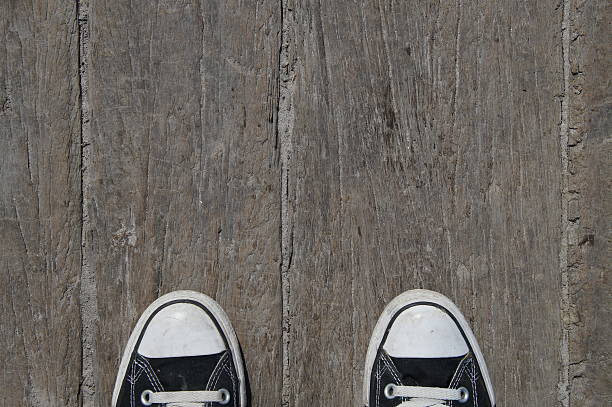 Black canvas baseball shoes on wood