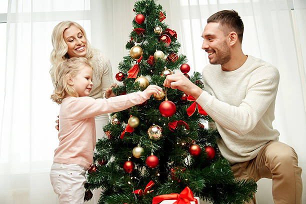 istock happy family decorating christmas tree at home 498466064