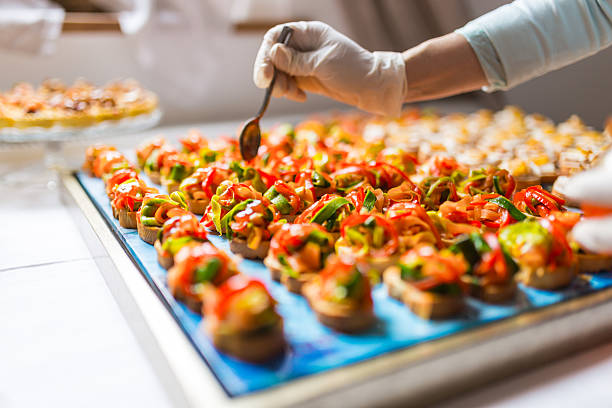 Final touch for tasty canapes Chef is using gloves for adding the final dressing on delicious canapes canape stock pictures, royalty-free photos & images