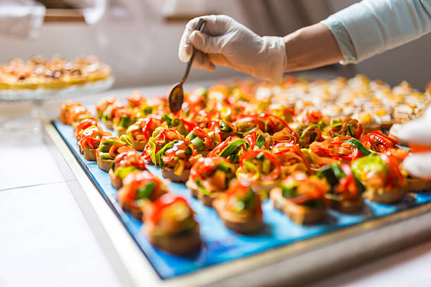 Final touch for tasty canapes Chef is using gloves for adding the final dressing on delicious canapes food service occupation stock pictures, royalty-free photos & images