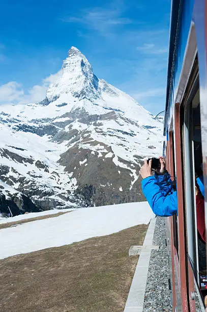 Tourist taking photo of Zermatt from the train in Switzerland