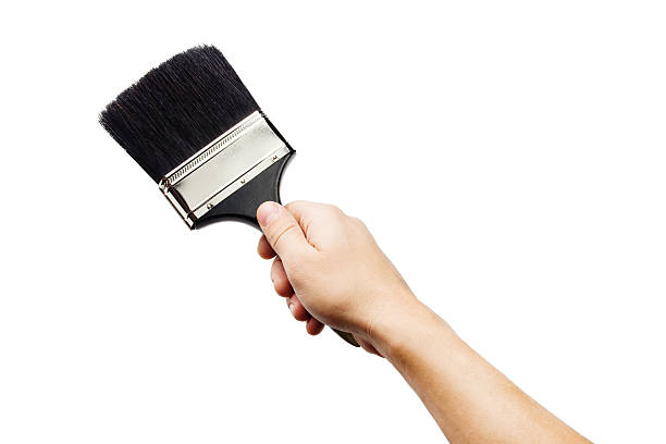 istock Hand holding big paintbrush isolated on white 498475335