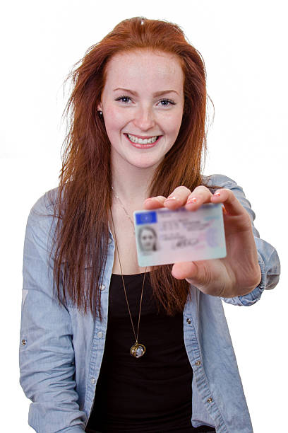 junge frau mit ihrem führerschein - id card identity showing women stock-fotos und bilder