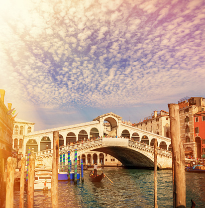 The Rialto Bridge .The Rialto Bridge (Italian: Ponte di Rialto) is one of the four bridges spanning the Grand Canal in Venice, Italy. It is the oldest bridge across the canal, and was the dividing line for the districts of San Marco and San Polo.http://stocklightbox.net/images/VENICE%20IMAGES.jpg 