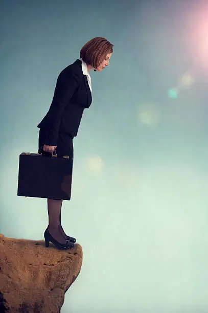 businesswoman standing on the edge of a cliff