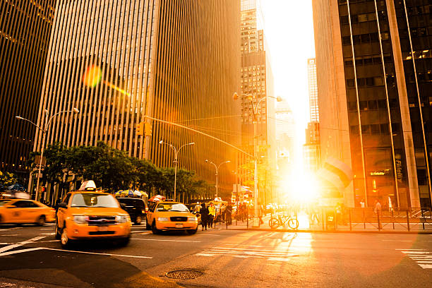 New York City Yellow cab is rushing trough the city in the sunset time. Manhattan, New York City, US. sun exposure stock pictures, royalty-free photos & images