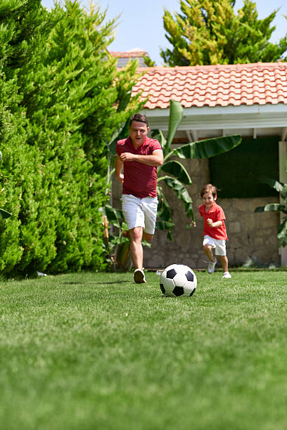 istock Father and son playing football 498490312