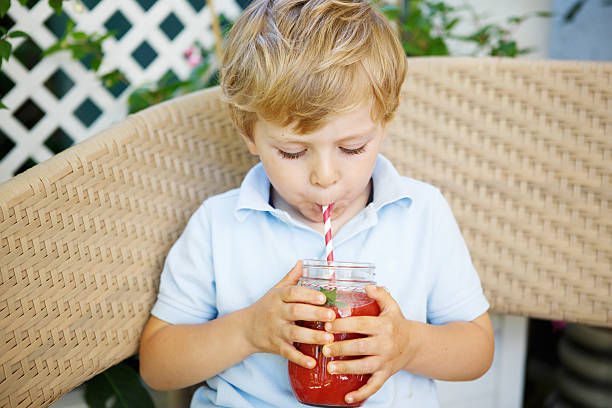 istock Little blond boy drinking healthy watermelon juice in summer. 498491689