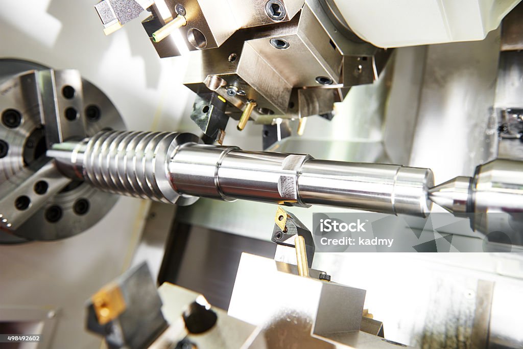 cutting tool at metal working metalworking  industry. cutting tool processing steel metal shaft on lathe machine in workshop CNC Machine Stock Photo