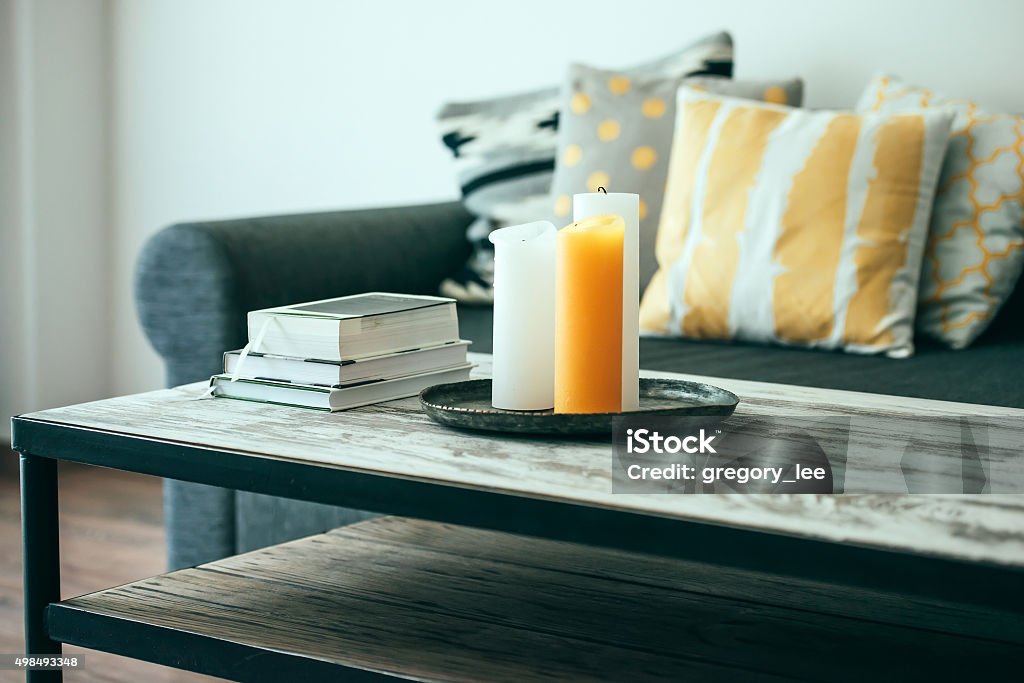Sofa Modern wooden coffee table and cozy sofa with pillows. Living room interior and home decor concept. Toned image Coffee Table Stock Photo