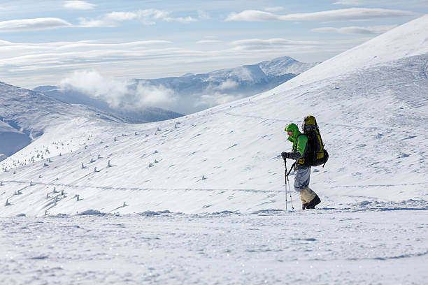 istock Backpacker man walking in winter mountains on sunny day 498495048