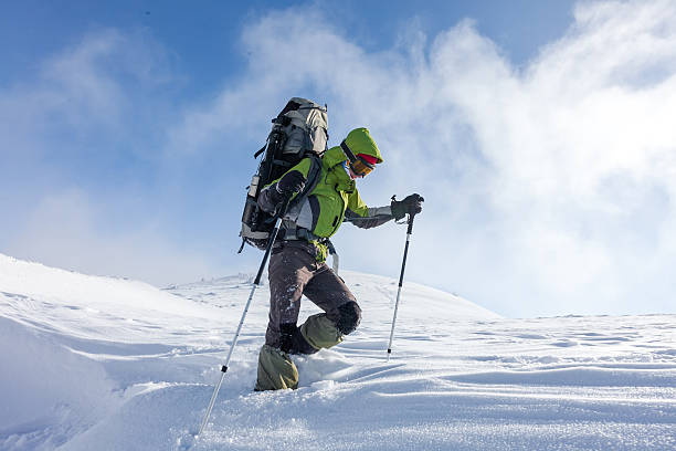 istock Backpacker woman is walking in winter mountains on sunny day 498495336