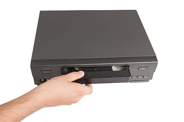 istock hand inserts videocassette in videorecorder isolated on white background 498495929