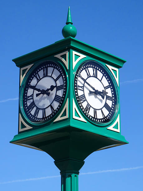 Image of green metal clock tower / clockface with Roman numerals