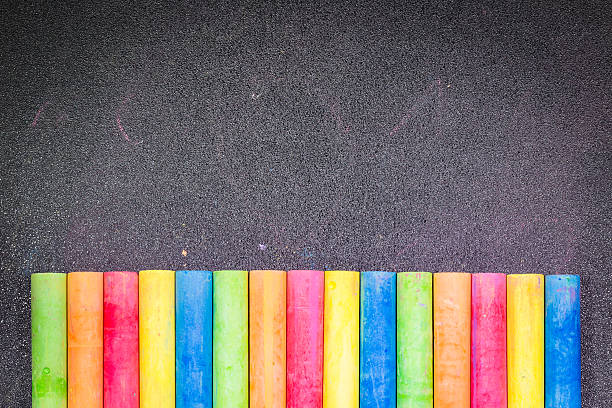 istock Row of rainbow colored chalk on blackboard 498497320