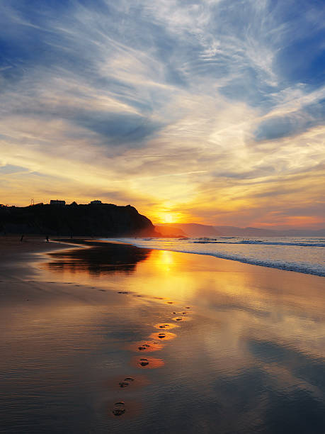 sunset in Sopelana beach with footprints sunset in Sopelana beach with footprints on the sand sopelana stock pictures, royalty-free photos & images