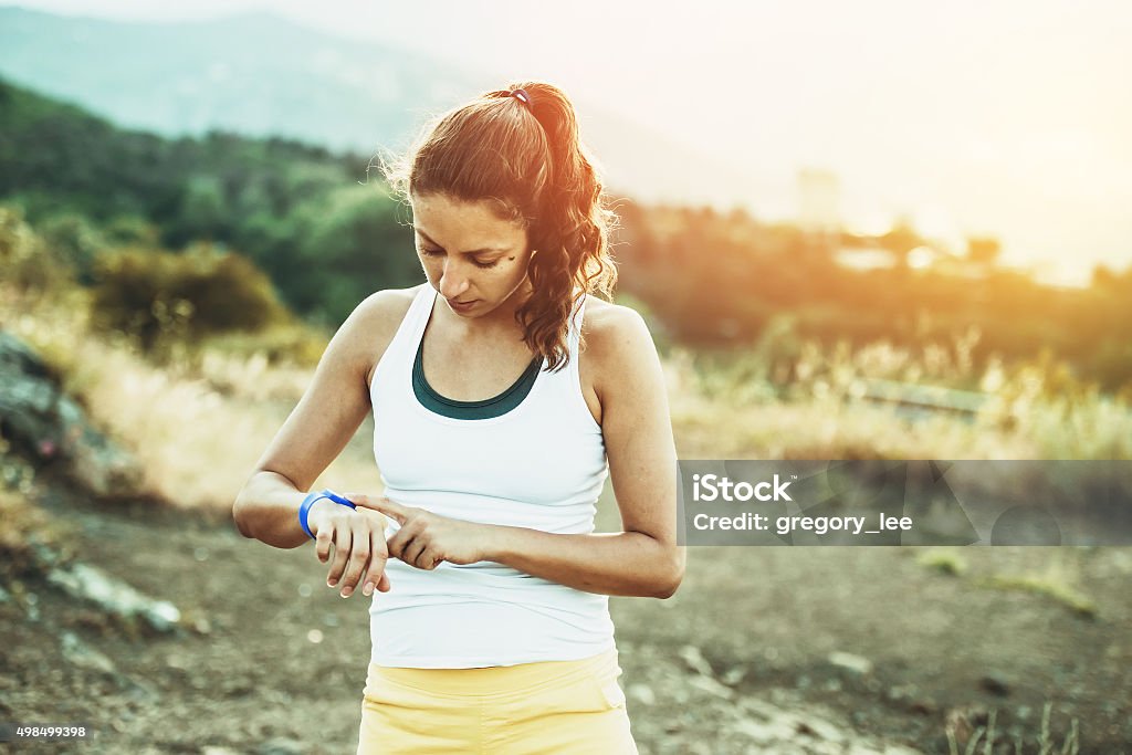 Sport Woman using activity tracker. Outdoor fitness concept. Toned image 2015 Stock Photo