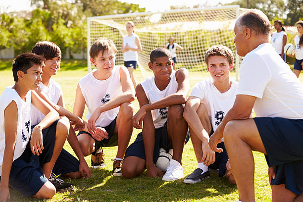 trener daje zespołowi porozmawiać z mężczyzna high school w piłce nożnej - football child american football team zdjęcia i obrazy z banku zdjęć