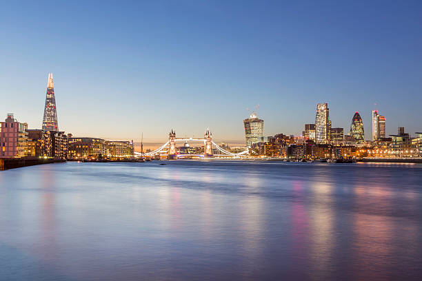 London skyline at dusk View of London's skyline with The Shard, Tower Bridge and City of London at dusk. gherkin london night stock pictures, royalty-free photos & images