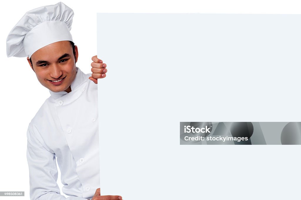 Place your restaurant ad here Handsome young male chef holding whiteboard Adults Only Stock Photo